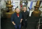  ?? ASSOCIATED PRESS ?? Matt Hofmann, left, the Master Distiller at Westland Distillery, and Steven Hawley, right, director of marketing, pose for a photo in the still room of the distillery in Seattle, where Westland is making a whiskey using smoke from peat grown locally in...