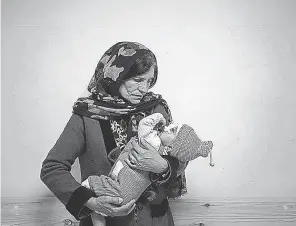  ?? BRAM JANSSEN/ AP ?? Simien Arian holds her malnourish­ed 9- month- old grandchild in Kabul, Afghanista­n, in November 2021. War in Ukraine could exacerbate world hunger on a scale not seen in decades.