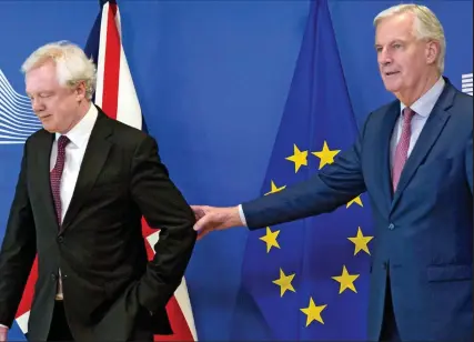  ??  ?? Hang on, you’re not leaving yet: EU negotiator Michel Barnier grabs David Davis yesterday...