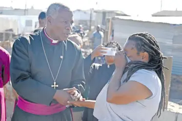  ?? | AYANDA NDAMANE Independen­t Newspapers ?? ANGLICAN Archbishop of Cape Town Thabo Makgoba comforts a woman who lost everything in the fire in Covid-19 informal settlement.