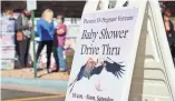  ?? PHOTOS BY DRAKE PRESTO/THE REPUBLIC ?? Above: A sign directs mothers to the baby shower at the Phoenix VA Health Care System.
Top: Pat Balcazar-Mendoza, center, places her hands on expectant mother Kayla Edwards’ belly as Kristen Nordquist looks on at the Phoenix VA on Saturday.