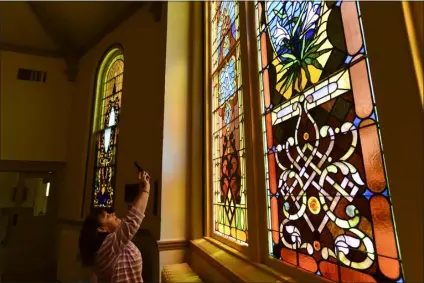  ?? MATTHEW JONAS/STAFF PHOTOGRAPH­ER ?? Jane Watkins, of Watkins Stained Glass in Denver, takes a photo of one of the stained glass windows at Grace Commons, formerly known as First Presbyteri­an Church, in Boulder on Wednesday. Watkins is giving a presentati­on on the history of the windows on Saturday.