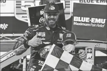  ?? STEVE HELBER/AP ?? MARTIN TRUEX JR. GIVES A THUMBS-UP as he celebrates with a fan after winning a NASCAR Cup Series race at Martinsvil­le Speedway in Martinsvil­le, Va. on Sunday.