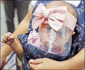  ?? AP ?? A six-month-old baby wears a face shield to help protect herself from the coronaviru­s in Manila the other day.