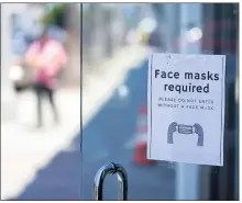  ?? JOSE SANCHEZ THE ASSOCIATED PRESS ?? A sign outside a store advises people on Monday to wear masks while shopping in the Fairfax district of Los Angeles, as the county’s coronaviru­s cases continue to rise.