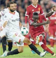  ?? — AFP ?? Liverpool’s Sadio Mane (right) has a shot on goal during the UEFA Champions League Group E match at Anfield.