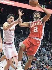  ?? John Amis / AP ?? Atlanta’s Tyler Dorsey (2) shoots as Devin Booker defends.