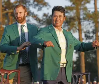  ?? FOTO REUTERS ?? Hideki Matsuyama krijgt het groene jasje aangereikt van Dustin Johnson, de uittredend­e winnaar.