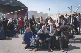  ?? AP PHOTO/FATIMA SHBAIR ?? On Monday, Palestinia­ns wait to cross into Egypt at the Rafah border crossing in the Gaza Strip.