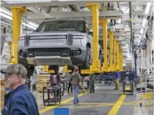  ?? BRIAN CASSELLA/CHICAGO TRIBUNE/TNS ?? R1T trucks move along the assembly line at the Rivian electric vehicle plant in 2022 in Normal, Ill.