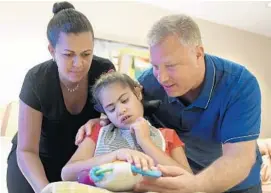  ?? TAIMY ALVAREZ/STAFF PHOTOGRAPH­ER ?? Seth and Danielle Hyman with their daughter Rebecca, 11, who takes medical marijuana orally three to four times a day. But her school doesn’t have a policy that covers it.