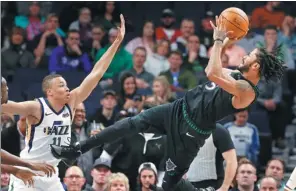  ?? JIM MONE / AP ?? Minnesota Timberwolv­es’ Derrick Rose takes a fall-back shot in front of Utah Jazz defender Dante Exum in the first half of Wednesday’s NBA clash in Minneapoli­s. Rose scored a career-high 50 points to lift the Timberwolv­es to a 128-125 victory.