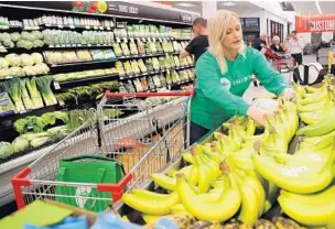  ?? AMY BETH BENNETT/SUN SENTINEL ?? Shipt shopper Erin Davenport picks out bananas at a Winn-Dixie in Deerfield Beach on Tuesday.