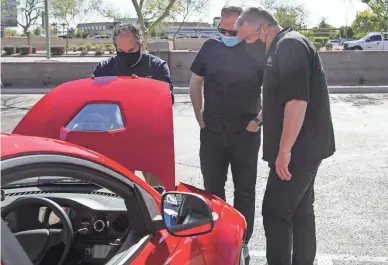  ?? MEG POTTER/THE REPUBLIC ?? Lawrence Shapiro (left) opens the hood of the new three-wheel electric Solo car from Electra Meccanica so Ed Capen (right) and Matt Llewellyn of the Barrett-Jackson Auction Company can take a look.