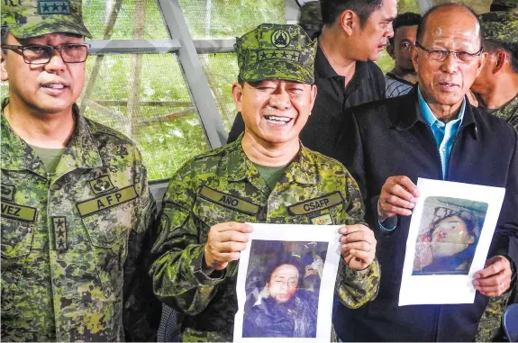  ?? AGENCE FRANCE PRESSE ?? Military chief General Eduardo Ano (center) holds an image of Islamic militant leader Isnilon Hapilon, next to Defense Secretary Delfin Lorenzana (right) showing an image of Omarkhayam Maute, and Western Mindanao Commanding General Carlito Galvez...