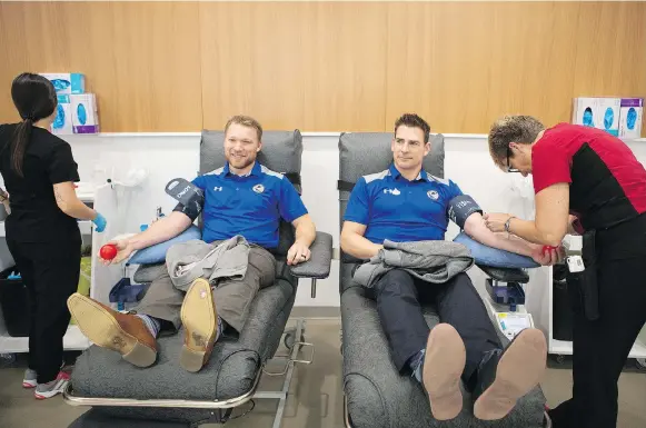  ?? KAYLE NEIS ?? Blades assistant coach Ryan Keller, left, and associate coach Ryan Marsh participat­e in the Hockey Gives Blood event to raise awareness at Canadian Blood Services on Saturday.