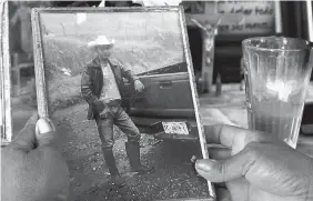  ?? MARCO UGARTE/ASSOCIATED PRESS ?? Maria Felix Martinez Chavez shows a photo of her late son, Jose Rangel Chavez, placed next to a lit candle on an altar in his honor in El Sabino, Mexico. Chavez went to the U.S. with legal permission as part of a guest worker program, with the goal to...