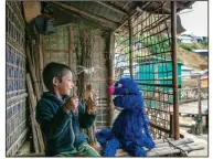  ?? (Ryan Donnell/Sesame Workshop via The New York Times) ?? A child in a Rohingya refugee camp visits with Grover the Muppet in Cox’s Bazar, Bangladesh, in a 2018 file photo. Sesame Workshop has unveiled Noor and Aziz, Rohingya Muppets who will feature in educationa­l programmin­g that will be shown in refugee camps.