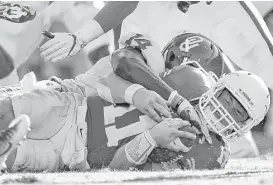  ??  ?? Oklahoma linebacker Emmanuel Beal, top, brings Texas quarterbac­k Sam Ehlinger to the ground hard on Saturday in Dallas.