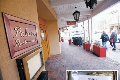  ?? LUIS SÁNCHEZ SATURNO/THE NEW MEXICAN ?? People walk past the closed Palace Restaurant &amp; Saloon on Wednesday, a day after the landlord posted a notice of lien on the door. Billy D. Harris Jr., who is behind the company that owns the property, declined to discuss the closing Wednesday.