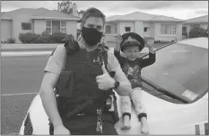  ?? LOANED PHOTO BY HONS ?? IN THIS PHOTO RELEASED BY NEW ZEALAND POLICE, an officer identified only as Constable Kurt sits on his patrol car with a 4-year-old boy who is not identified, in the South Island city of Invercargi­ll, New Zealand, Friday.