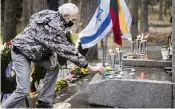  ?? MINDAUGAS KULBIS AP ?? Holocaust survivor Davidas Leibzonas places stones at the foot of a granite Holocaust survivor memorial in the Paneriai memorial during the ceremony marking the annual Holocaust Remembranc­e Day in Vilnius, Lithuania, on Thursday.
