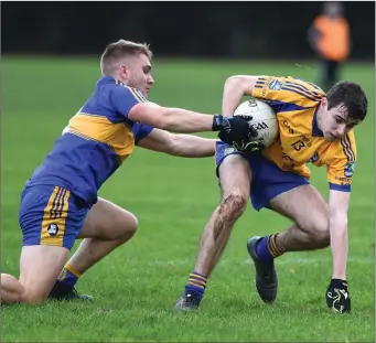  ??  ?? Beaufort’s Niall O’Connor holds onto possession despite the best efforts of Tadhg Geoghegan, Michael Cusacks, in the Munster Club JFC semi-final at Beaufort on Saturday.