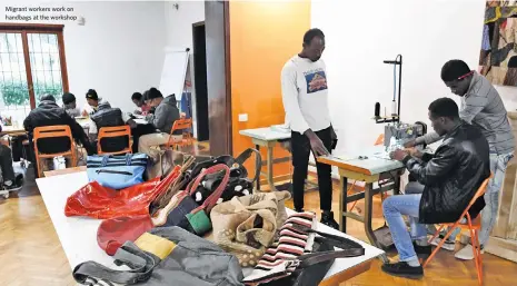  ??  ?? Migrant workers work on handbags at the workshop