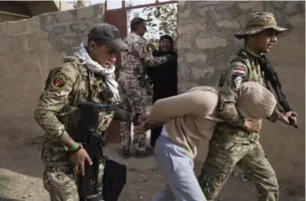  ?? ALI ARKADY PHOTOS/VII PHOTO ?? An ERD soldier locks his arm around the neck of detainee Raad Hindiya, custodian of Qabir al-Abid mosque.