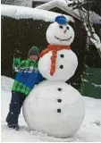  ??  ?? Michael, 10, mit seinem Schneemann, der in einer Familienge­meinschaft­sproduktio­n entstanden ist.