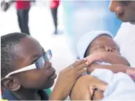  ??  ?? Rudean touches his brother, Sae’breon Hutton, in the arms of their mother, Suzett Whyte.