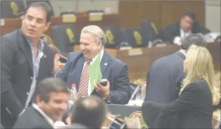 ??  ?? El senador cartista Óscar González Daher (c) festeja sonriente tras la votación en la que no hubo la mayoría necesaria para aprobar la resolución que disponía sancionarl­o con dos meses de suspensión sin goce de sueldo.
