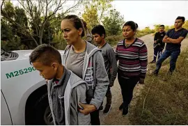  ?? CAROLYN COLE / LOS ANGELES TIMES ?? Migrants in McAllen, Texas, wait to be transporte­d to a detention center.