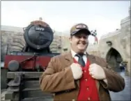  ?? THE ASSOCIATED PRESS ?? A station agent greets guests in front of the Hogwarts Express train at the Wizarding World of Harry Potter at Universal Studios in Orlando, Fla.