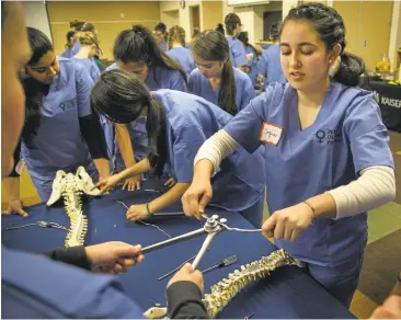  ?? PATRICK TEHAN/STAFF ?? Sofia Herrera, 16, of Hayward, and other participan­ts learn to do spinal fusion during a workshop put on by the Perry Initiative's outreach program.