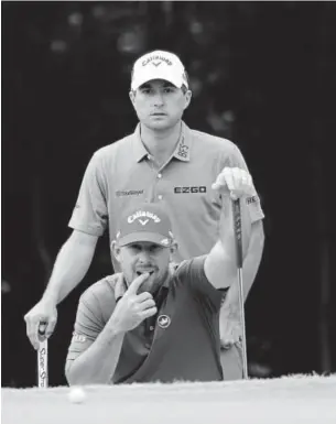  ?? Rob Carr, Getty Images ?? Kevin Kisner and Scott Brown line up a putt during the third round of the Zurich Classic at TPC Louisiana in Avondale on Saturday.