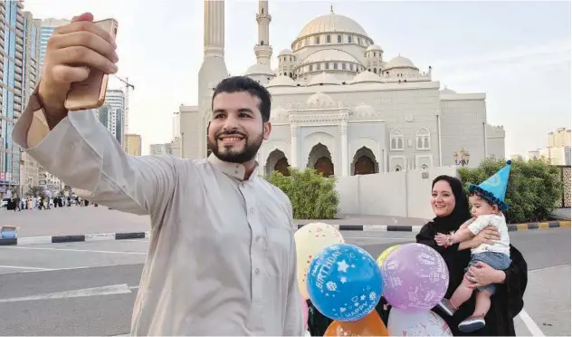  ?? Kamal Kassim/gulf Today ?? ↑
A family enjoys the celebrator­y spirit of Eid outside Al Noor Mosque in Sharjah.