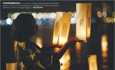  ?? REUTERSPIX ?? IN REMEMBRANC­E ... A woman in Brasilia, Brazil prepares to set adrift lanterns, with the names of people who died from coronaviru­s, during the Japanese ceremony of Tooro Nagashi. –