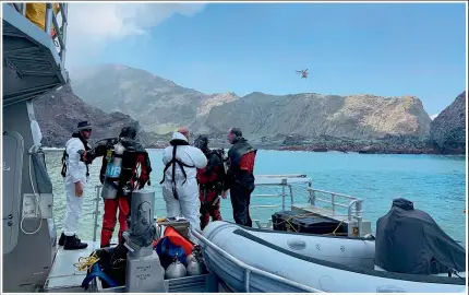  ??  ?? Tributes to the victims line the cordon on the Whakata¯ne waterfront, right, after the eruption of Whakaari/White Island as police divers yesterday continued their search for the remaining two bodies.