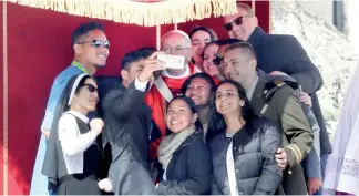  ?? AP ?? El papa Francisco se toma una “selfie” con jóvenes.