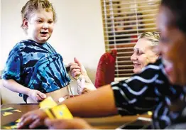  ?? Houston Chronicle via AP ?? n Zechariah, 10, left, talks on June 26 to a teacher from Houston Independen­t School District’s Community Services, right, as his grandmothe­r, Raine, center, gives him medicine through a tube in his stomach during a tutoring session at an extended-stay...