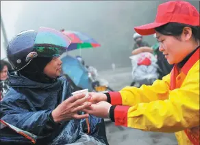  ?? PROVIDED TO CHINA DAILY ?? Volunteers of PetroChina in Fujian province provided migrant workers with free ginger soup as they returned home by motorcycle during last year’s Spring Festival.