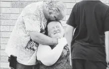  ?? MICHAEL CIAGLO THE ASSOCIATED PRESS ?? A man hugs a woman outside the Alamo Gym where parents wait to reunite with their children following a shooting at Santa Fe High School in Santa Fe, Texas, on Friday.