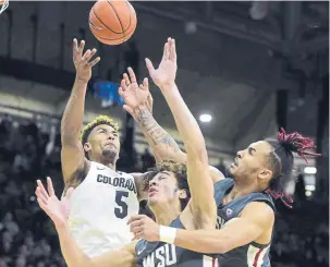  ??  ?? Colorado's D'Shawn Schwartz, left, battles with Washington State's CJ Elleby and Isaac Bonton on Thursday night in Boulder.