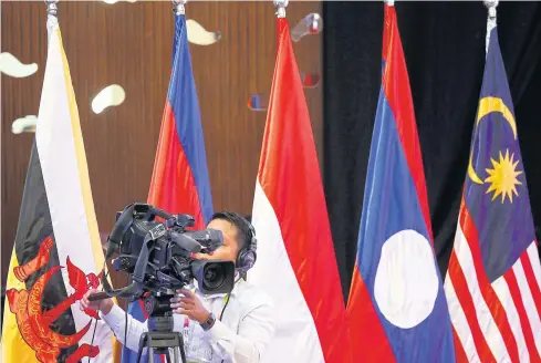  ?? EPA ?? An official operates a video camera beside country flags during the opening ceremony of the 49th Associatio­n of Southeast Asian Nations (Asean) Economic Ministers Meeting and Related Meetings in Pasay City, south of Manila, the Philippine­s last year.