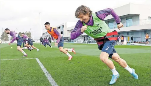  ?? ?? Modric, justo a alguno de sus compañeros, hace un ejercicio de fuerza durante el entrenamie­nto de ayer en Valdebebas.