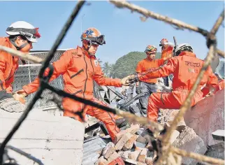  ??  ?? Rescue workers know as Topos Azteca clear the debris of a building damaged in an earthquake. — Reuters photo