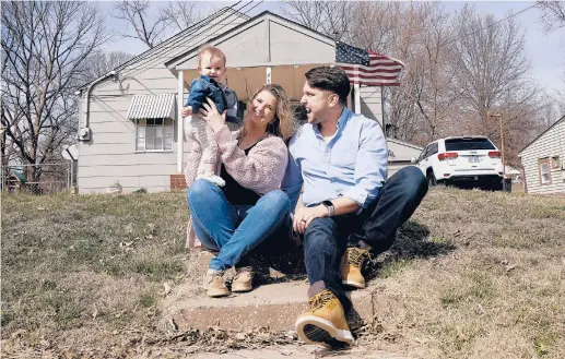  ?? CHARLIE RIEDEL/AP ?? Logan DeWitt with his wife, Mckenzie, and daughter Elizabeth sit on the steps leading to their home Monday in Kansas City, Kansas. Their financial situation during the pandemic was complicate­d with Elizabeth’s birth nine months ago and a job loss.