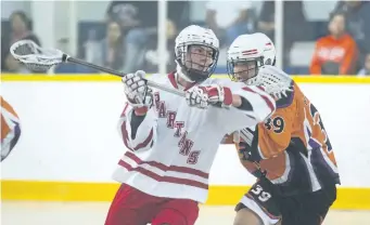  ?? JULIE JOCSAK/POSTMEDIA NEWSF ?? John Andrew Kit of St. Catharines Spartans tries to keep the ball ahead of Kahn General of the Six Nation Rebels in junior B lacrosse action at Merritton Arena in St. Catharines on Sunday.