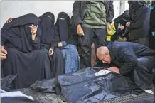  ?? AP photo ?? Palestinia­ns mourn relatives killed in the Israeli bombardmen­t of the Gaza Strip at a hospital in Rafah on Friday.